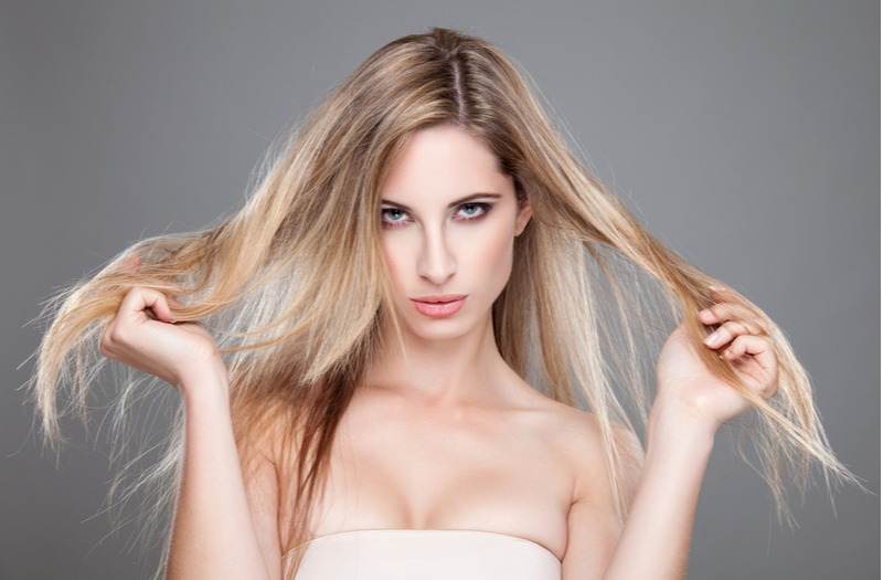 Người phụ nữ chỉ cho chúng tôi cách khắc phục mái tóc tẩy không đều màu bằng cách giữ chặt đuôi tóc một cách ghê tởm