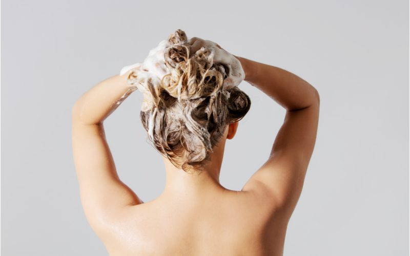 Woman over-washing her hair, causing her to ask why is my hair so oily?