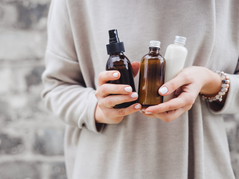 Woman using walnut oil for grey hair in three bottles