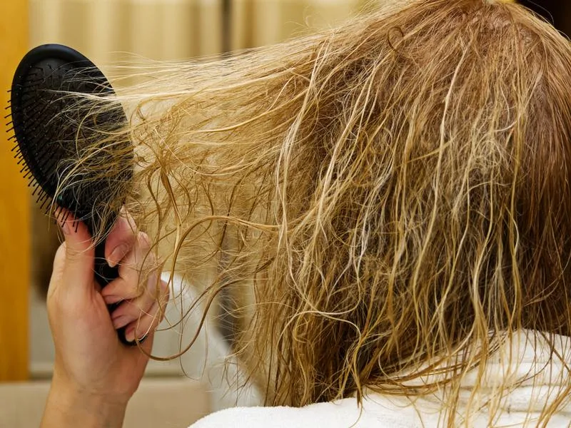 Woman fixing a bad peroxide hair dye job with a brush