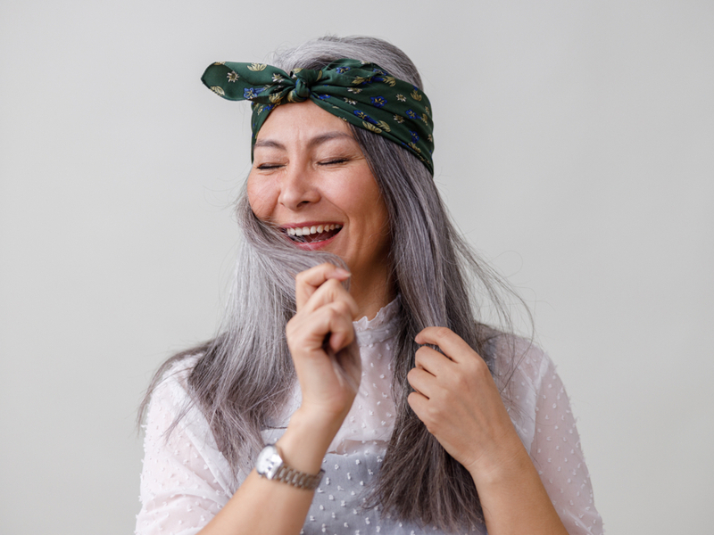 Woman smiling after using the best color-depositing shampoo for gray hair