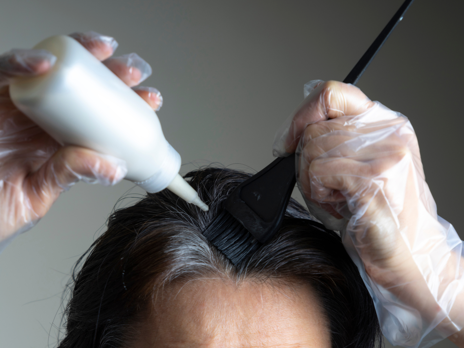Hình ảnh cho một mẩu có tiêu đề thời gian để lại thuốc nhuộm trên tóc cho thấy một người phụ nữ đang nhuộm tóc