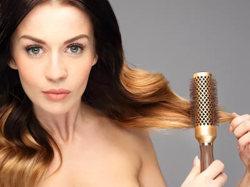 Woman making round brush curls in a studio