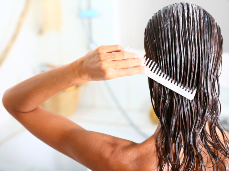 Woman in the shower using a deep conditioner to keep her hair color from fading