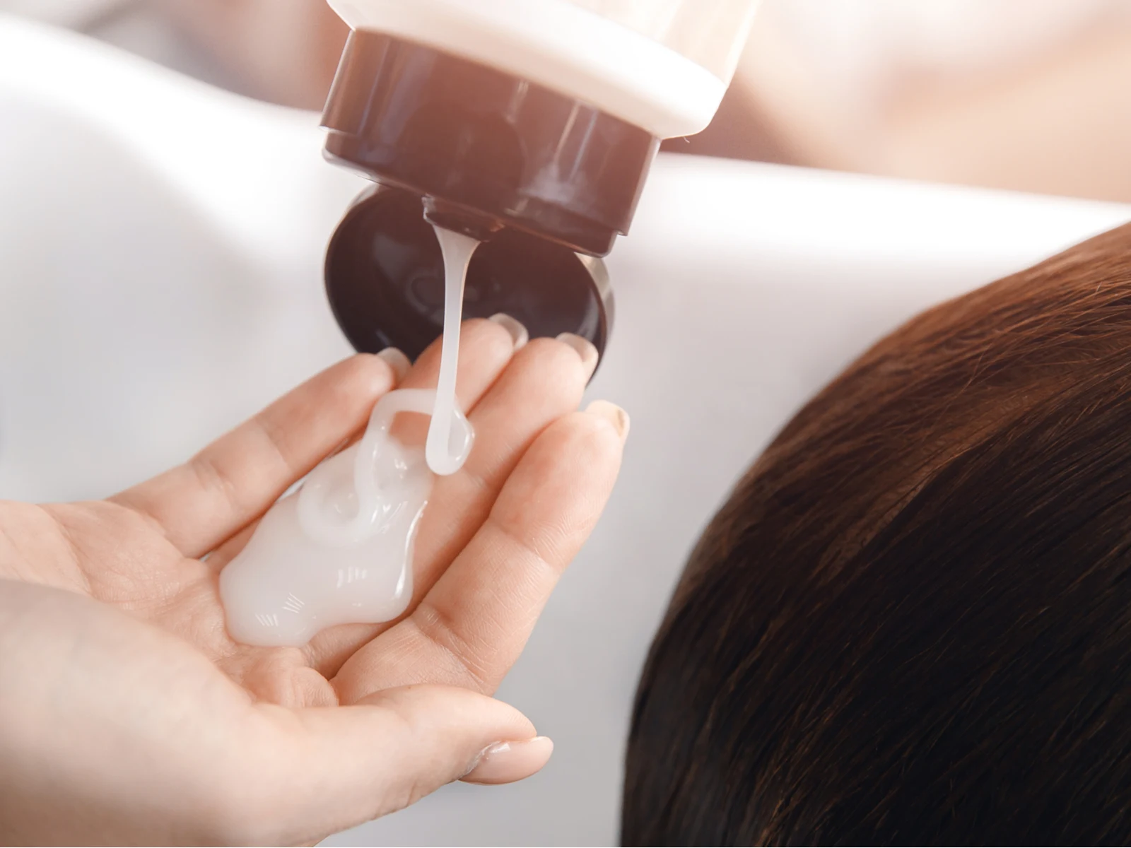 Hairstylist squirting gel into her hand for a piece titled what happens if you don't rinse conditioner out of your hair