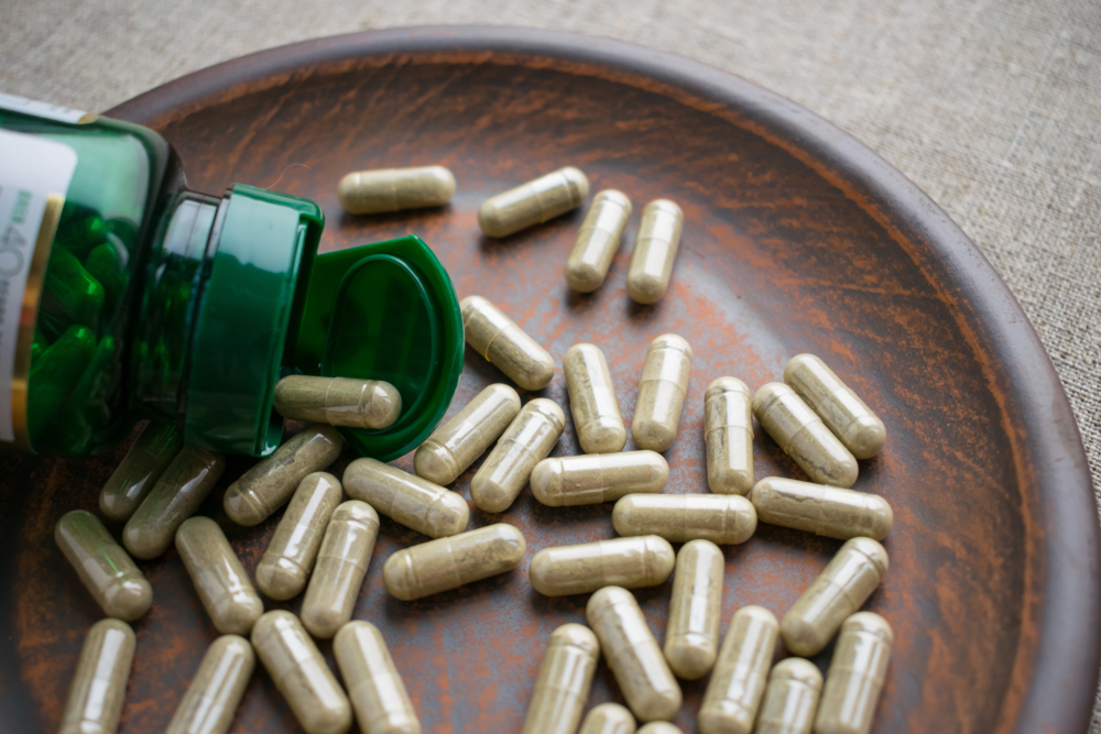 Several biotin capsules on a wooden dish for a piece titled How Long Does It Take Biotin to Work