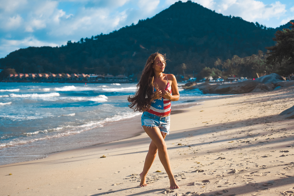 Woman with waist length hair on a beach in a bikini
