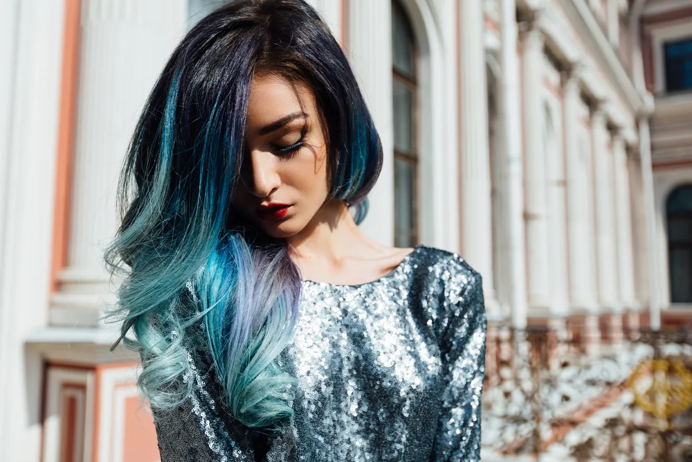 For a piece on how to dye your hair blue without bleach, a woman looking down and to the right