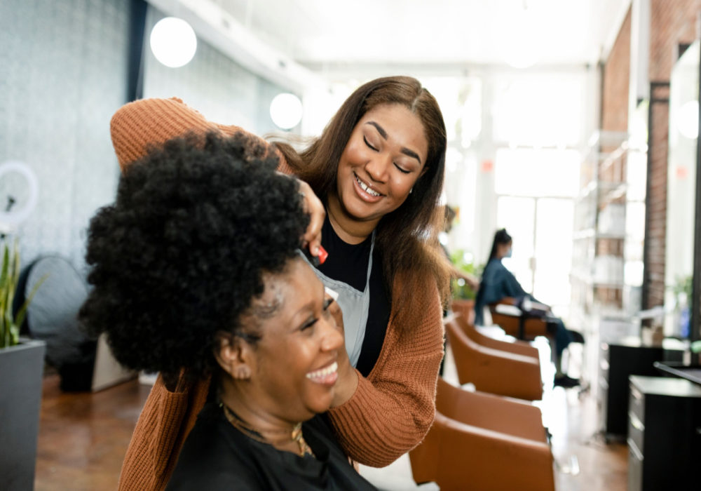 Woman in a hair salon getting her hair done for a piece on how to care for natural hair