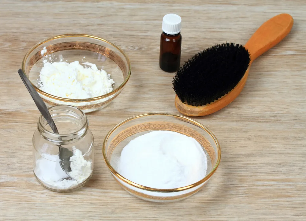 Baking soda next to a hair brush for a piece on stages of lightening dark hair