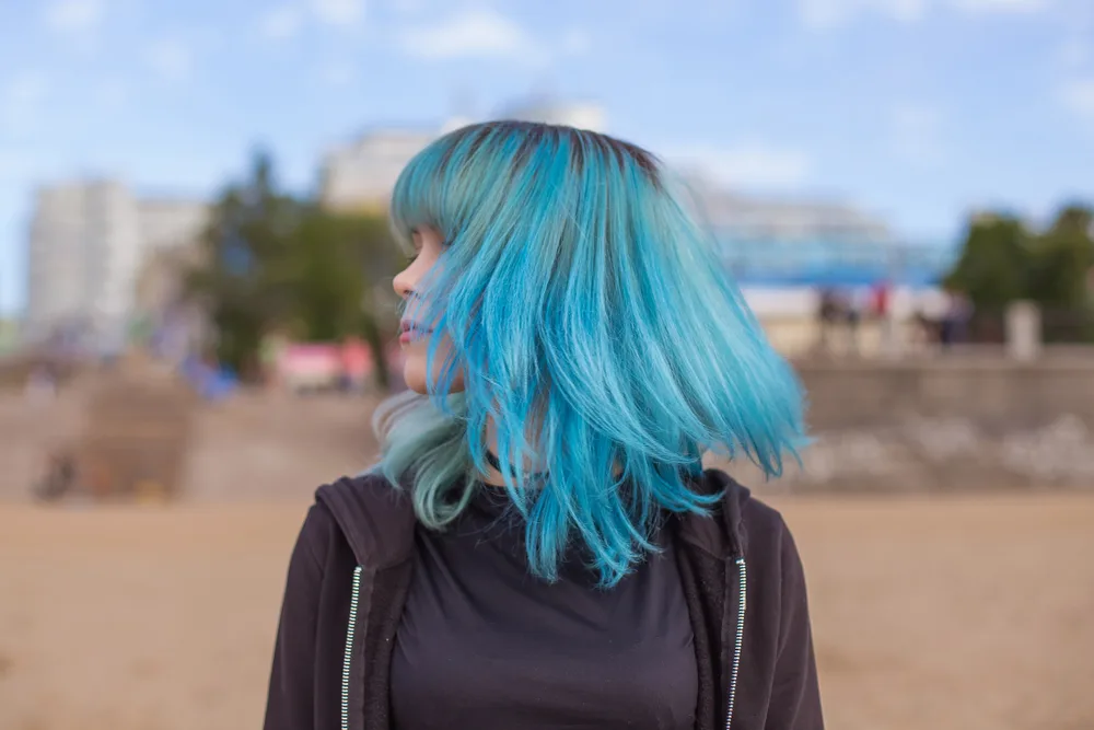 Woman with blue hair pictured for a piece titled the best pastel hair colors for brown eyes