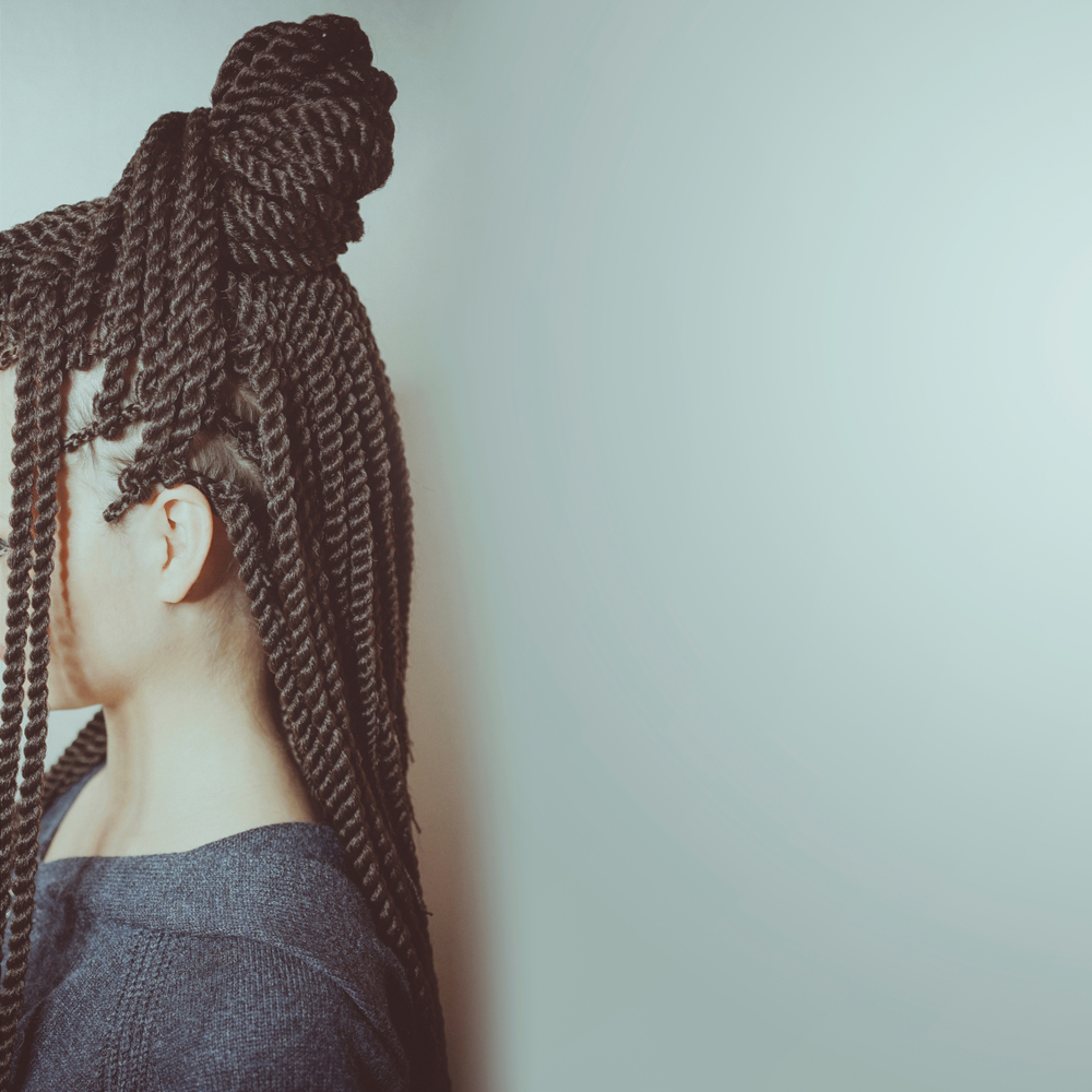 Half-Up, Half-Down Thai braids on a woman in a studio and you can't see her face