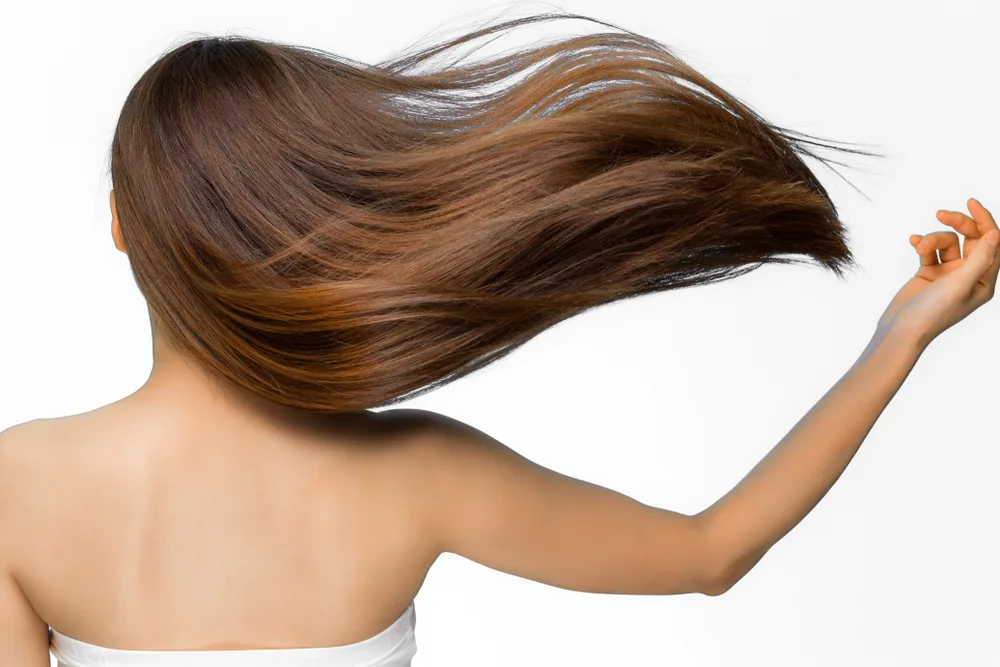 Bronzed Copper Red Brown Hair Color on a woman letting her long hair flow in the wind