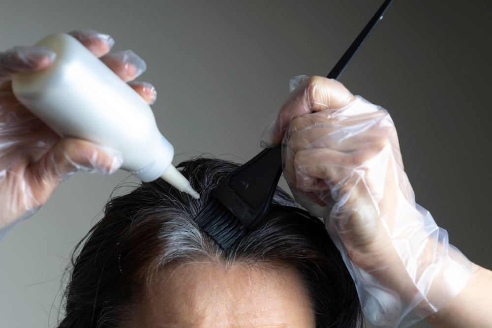 Người phụ nữ bôi thuốc nhuộm tóc bán vĩnh viễn lên đầu để xem một đoạn về cách sử dụng màu tóc bán vĩnh viễn Ion