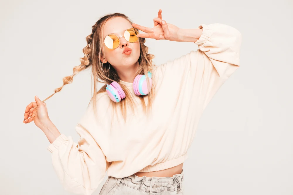 Bubble Braids, a trending y2k hairstyle, pictured on a woman in a beige shirt