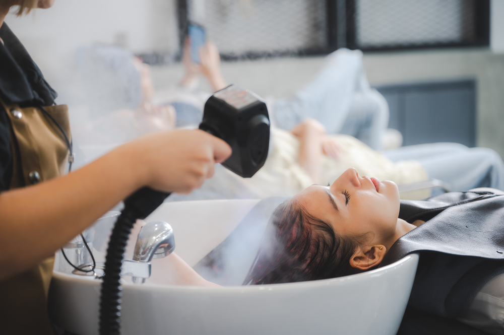 Hairdresser in a salon steaming a woman's hair with the best hair steamer