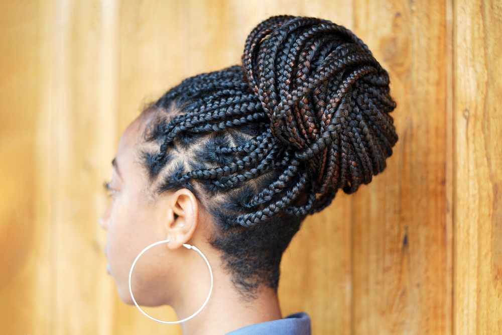 Big braids, one of the best hair styles for black women over 50, pictured from the side