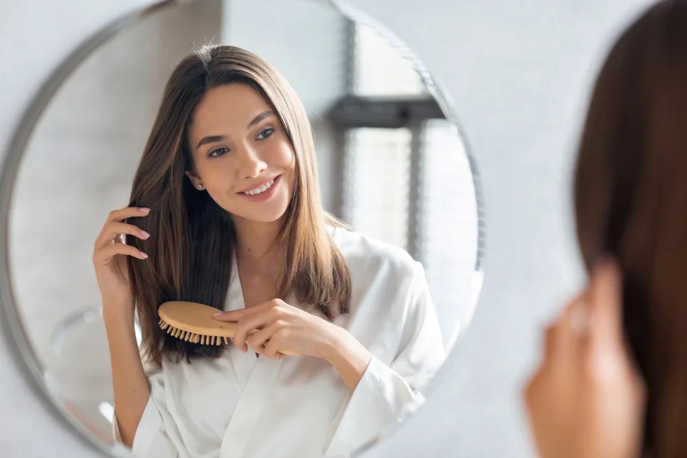 Woman brushing her healthy hair for a piece titled Does Pantene Cause Hair Loss