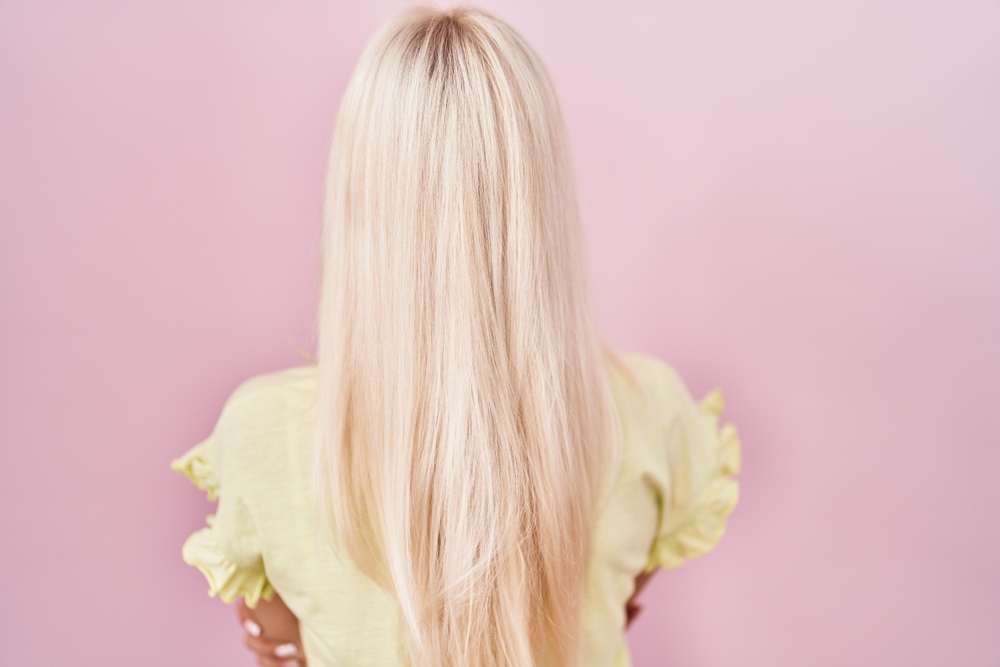 For a piece on the best summer hair colors, a woman wears Subtle Pink-Toned White Blonde color