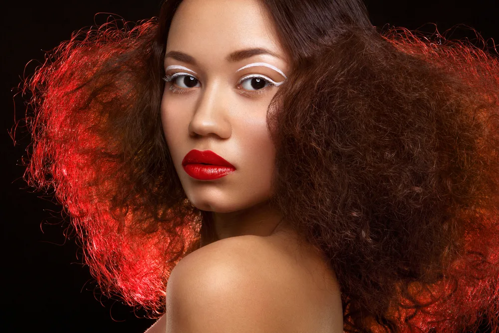 Black person with red hair and eye makeup