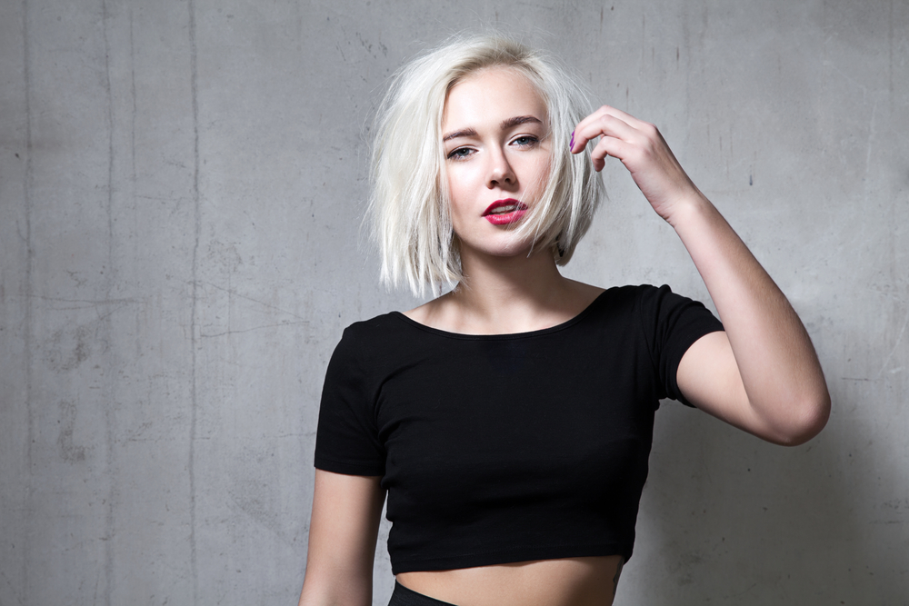 Woman with white hair in a black crop top pictured for a piece on the best hair colors for blue eyes