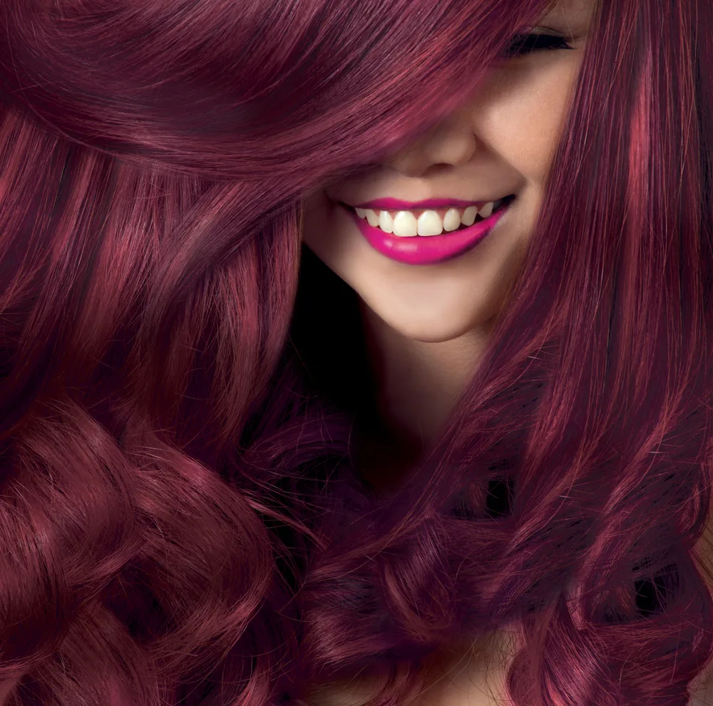 Model with a gorgeous smile and red lip and plum burgundy hair