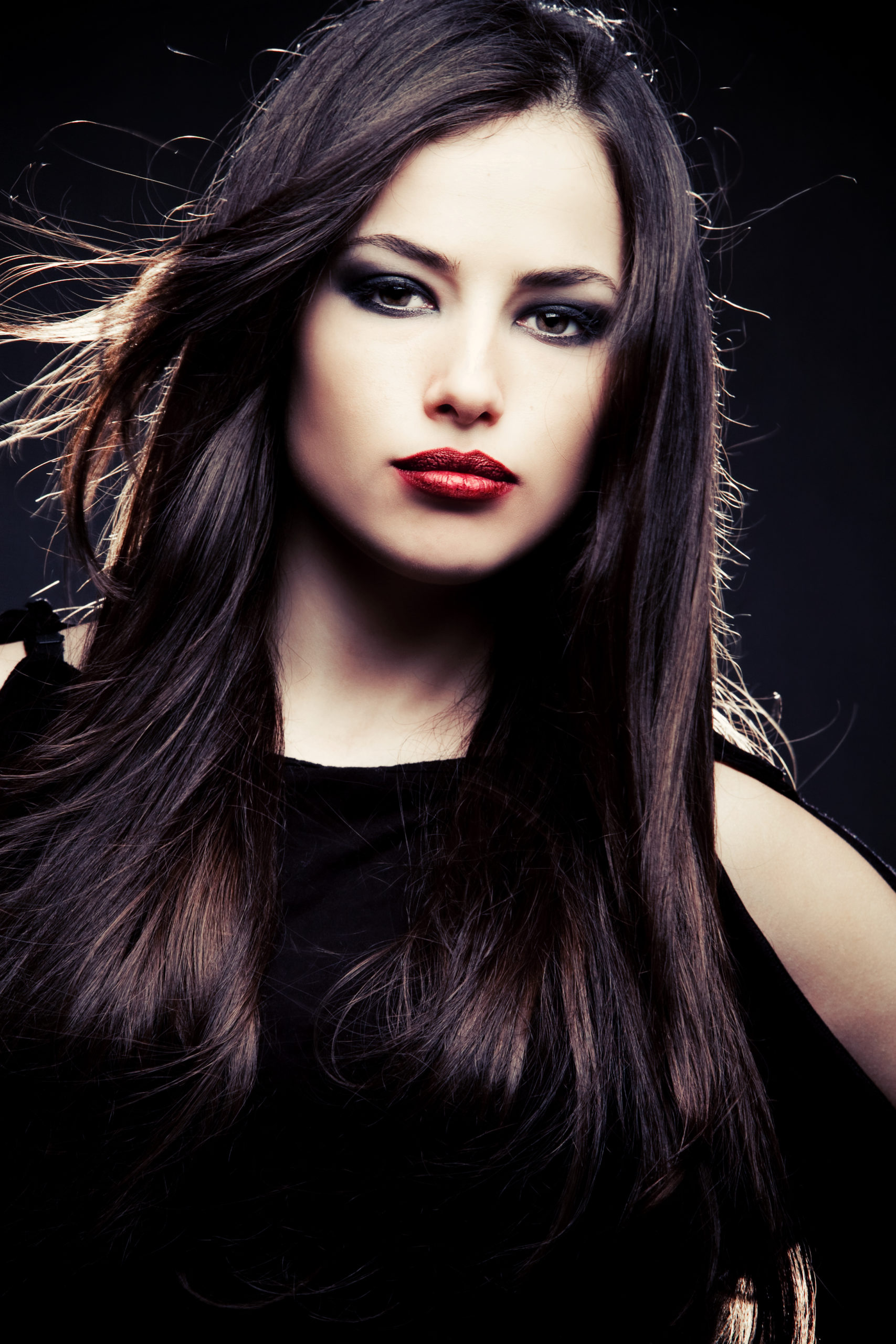 Black With Dark Chocolate Highlights, one of the best winter hair colors, on a woman in a black dress