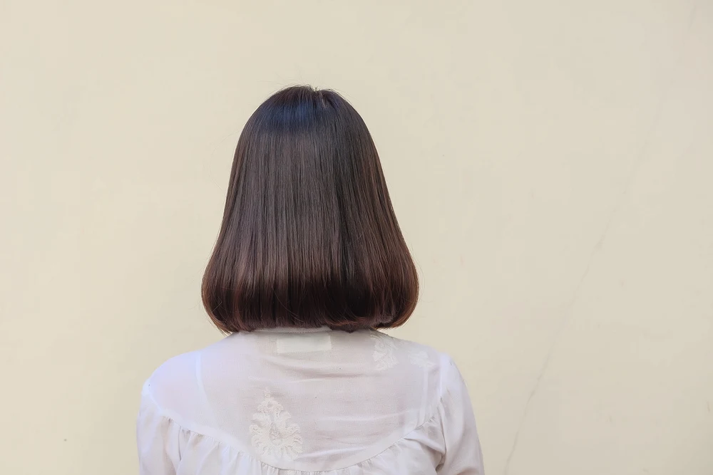 For a guide to dark brown hair color, a woman with Espresso to Dark Auburn Brown Sombre (Levels 3-4) as seen from the back