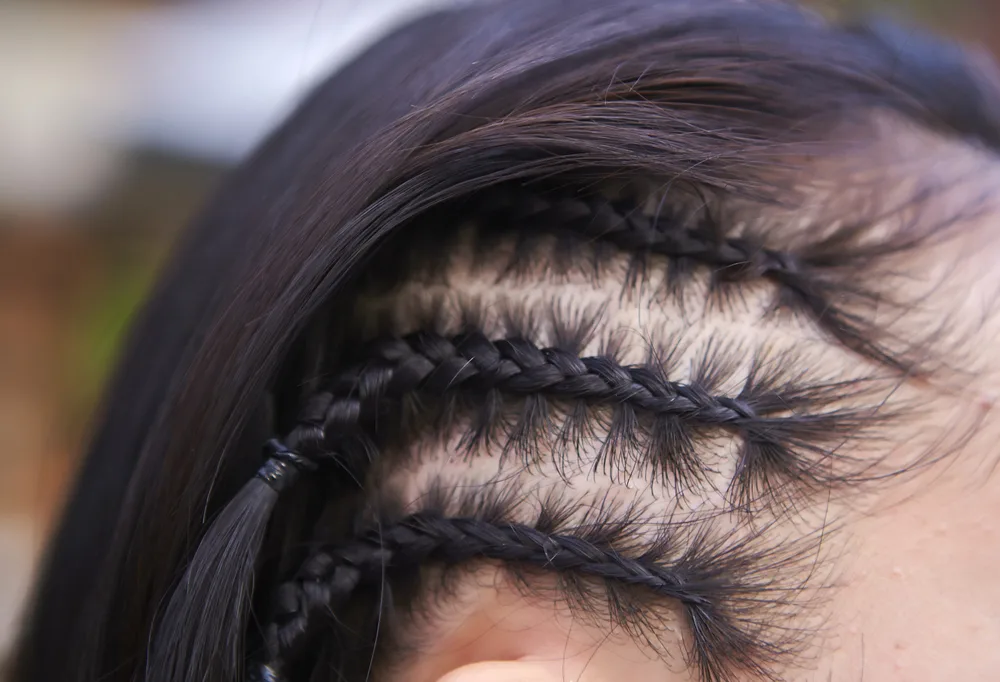 Half Cornrows, one of the best y2k hairstyles, pictured in an up-close image