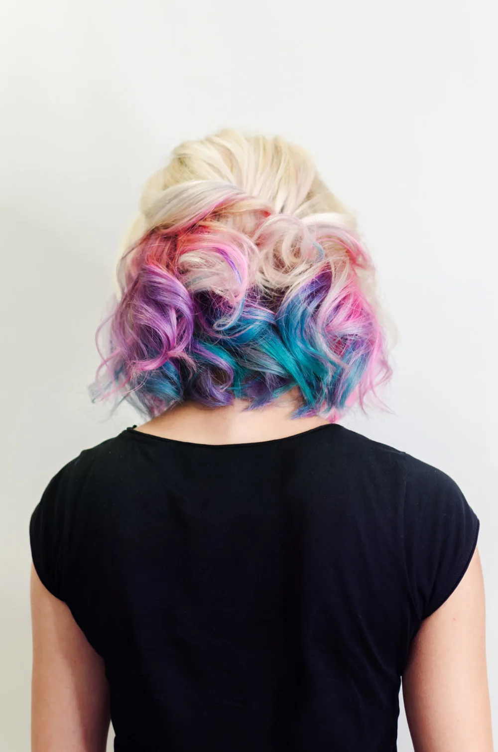 Lilac, Aquamarine, and Platinum Blonde multi colored hair ideas on a woman in a black shirt