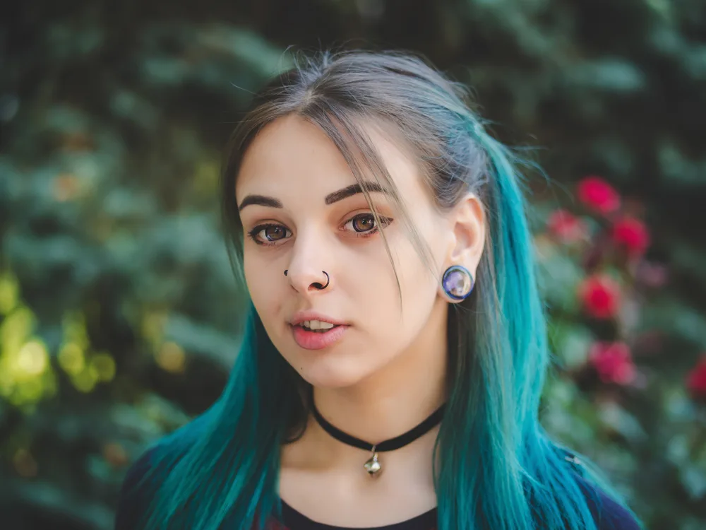 As a featured y2k hairstyle, a woman with blue hair rocks Half-Up Pigtails