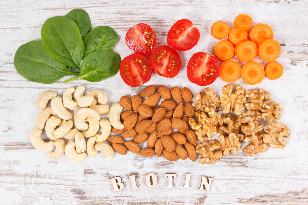 For a guide to the best time to take biotin, wooden letters spell out the word with nuts and veggies above it