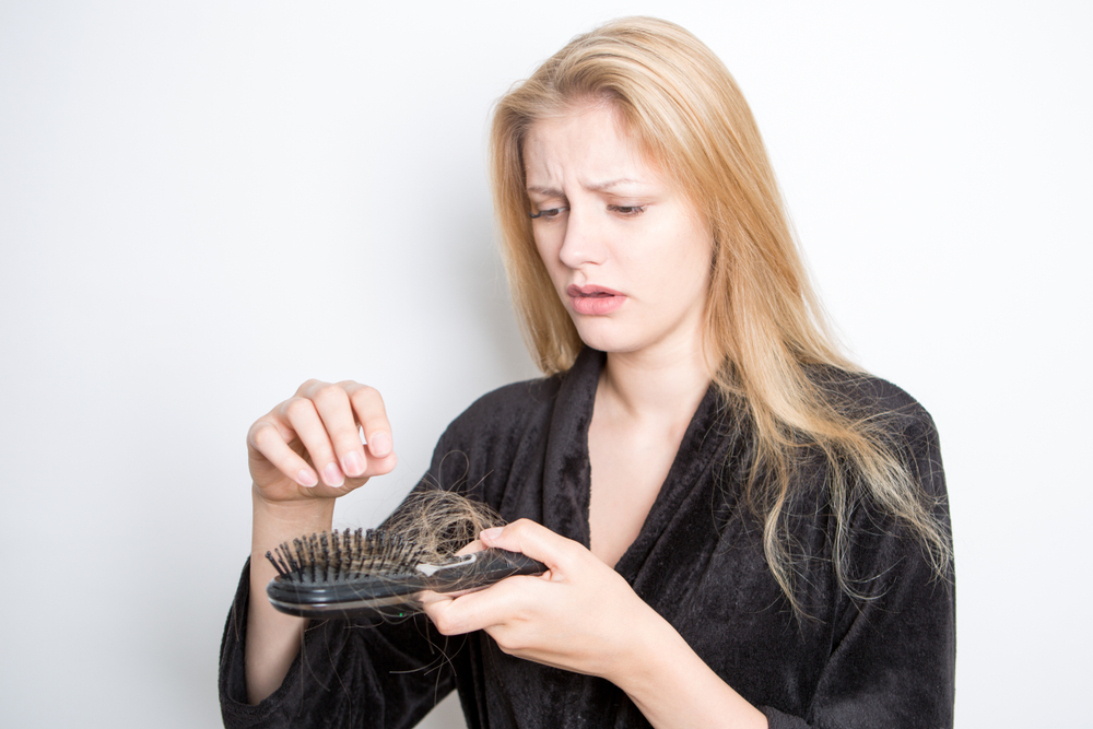 Woman worrying because her hair is falling out after bleaching