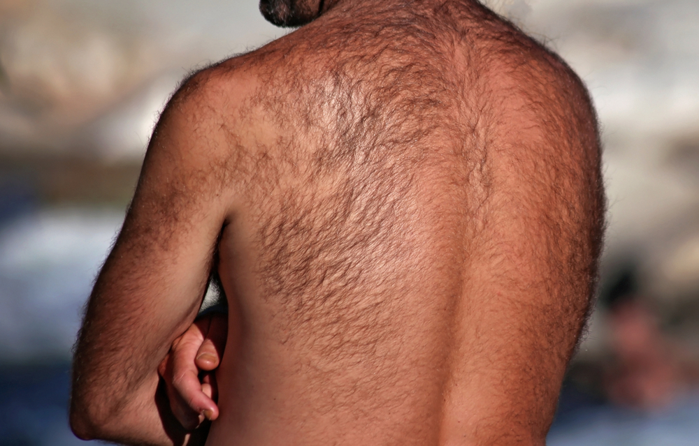 Man with lots of hair on his back crosses his arms