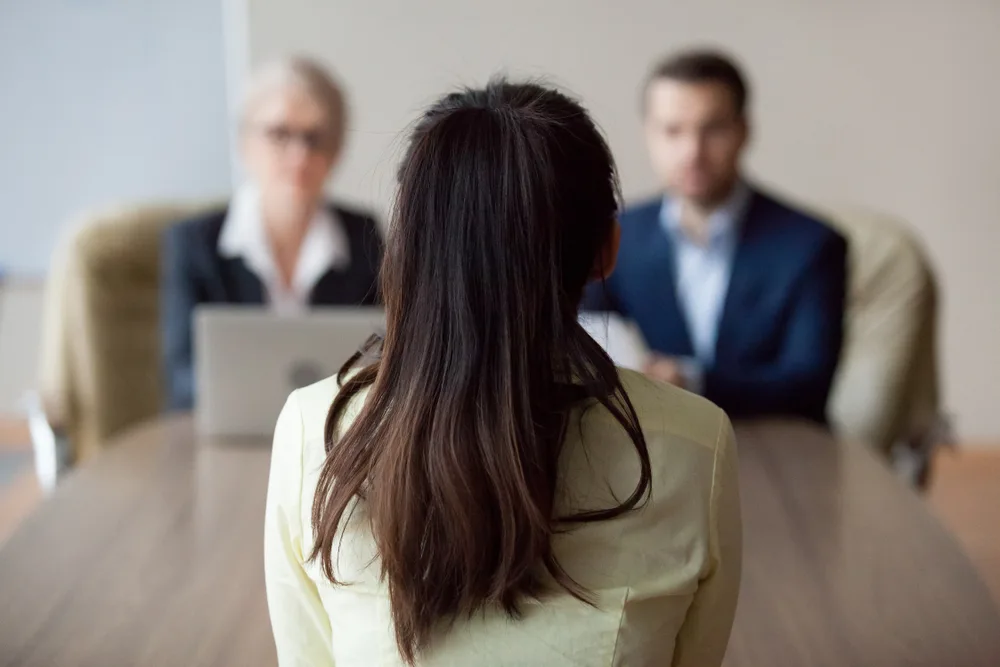 Woman with her hair up in a job interview as seen from behind