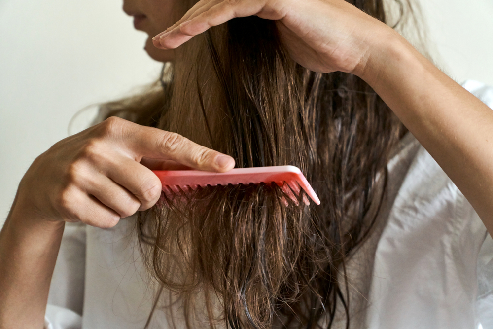 Woman detangling her hair to wash it after a keratin treatment