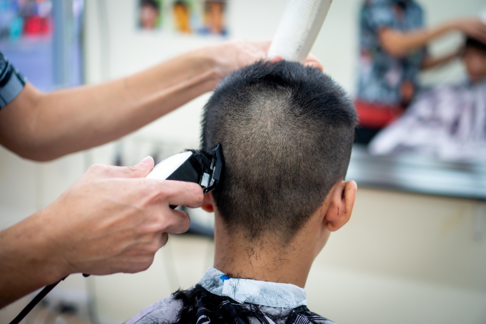 Người đàn ông bị cắt tóc buzz trong tiệm làm tóc