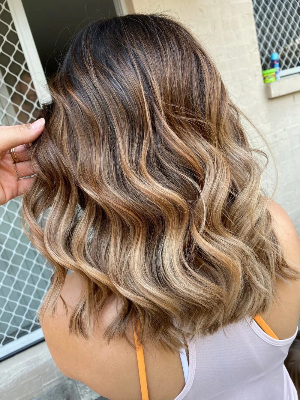 Woman with Multi-Toned Golden Brown and Blonde Balayage hair for a brown hair idea hairstyle roundup