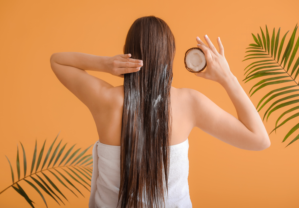 Woman using coconut oil on her hair to remove the hair dye