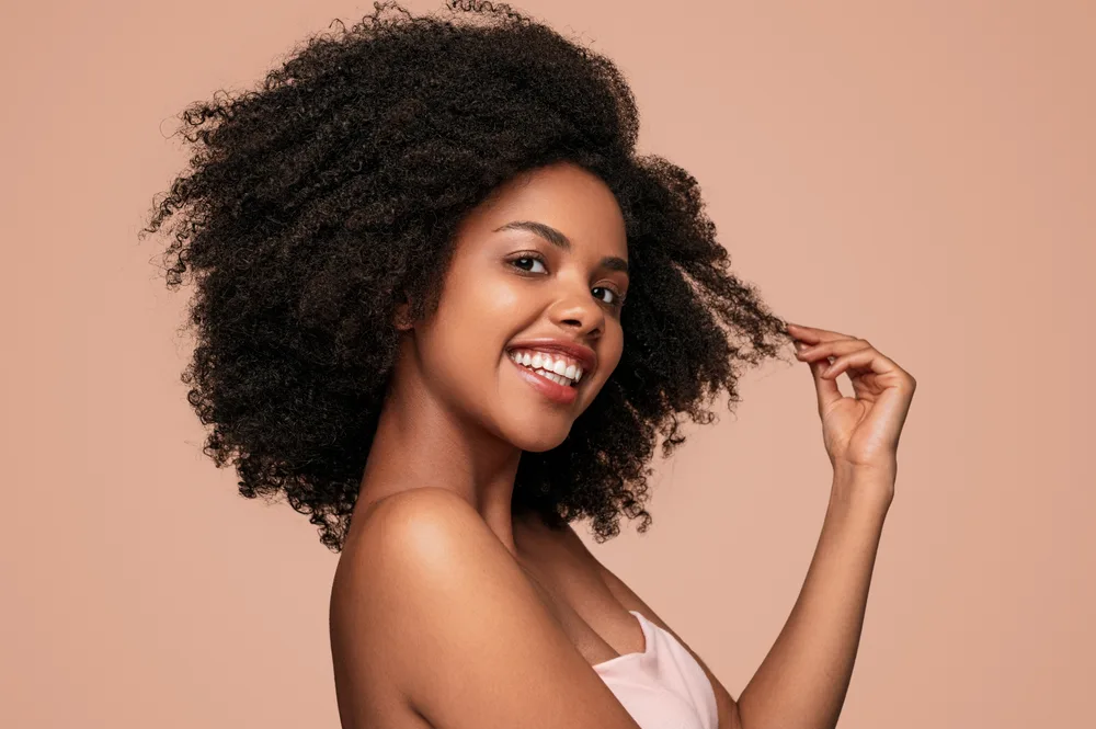 Confident woman smiling because she used our natural hair care tips for beginners