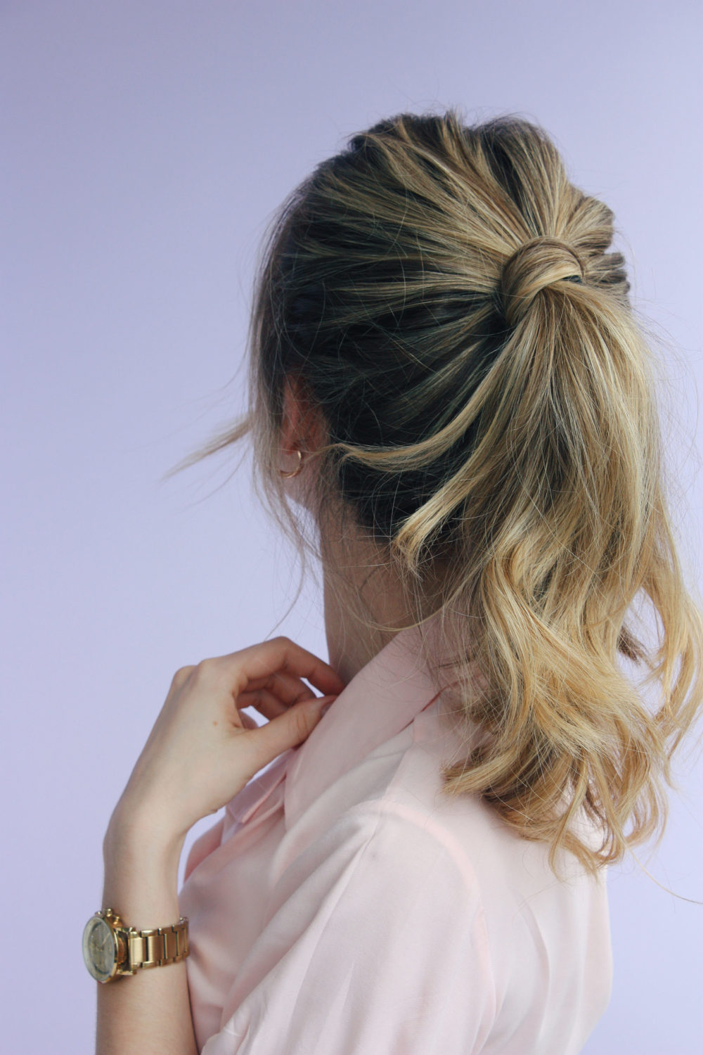 Fast Wrapped Ponytail, an easy hairstyle for women, on a model in a violet room