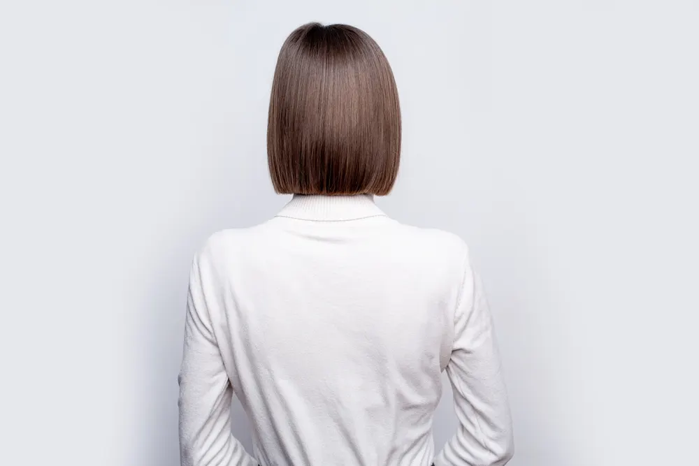 Midi Blunt Bob, a great short hairstyle for fine hair, pictured on a woman in a white shirt