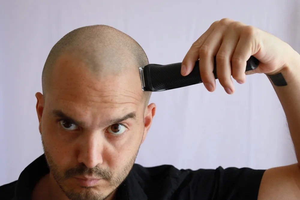 Man buzzing his hair for a guide to whether or not you should buzz your head
