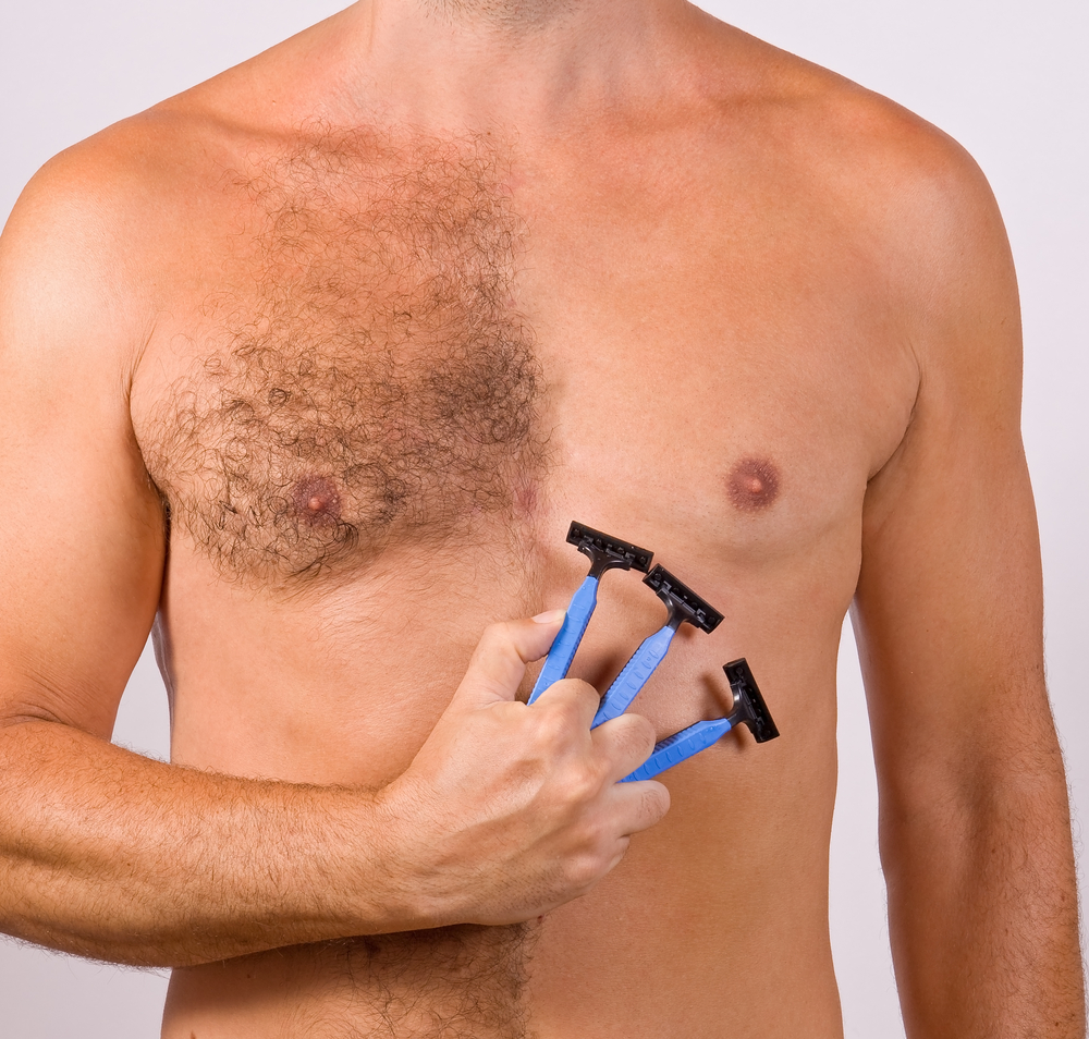 Man holding three razors in his fingertips for a piece on what is manscaping