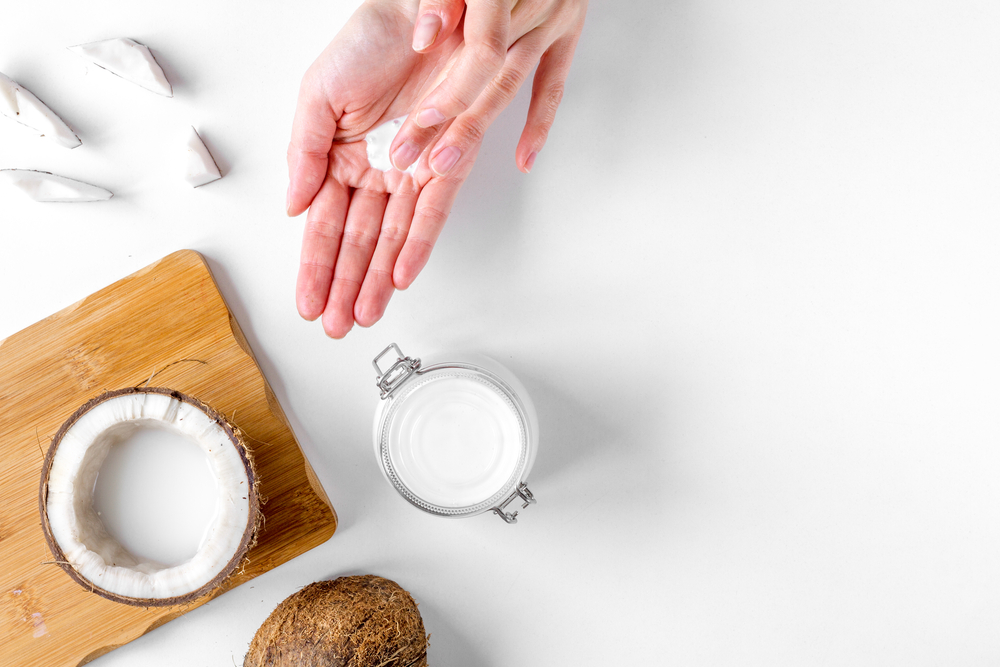 Image for a piece on does coconut oil remove hair dye featuring someone putting it on her hands