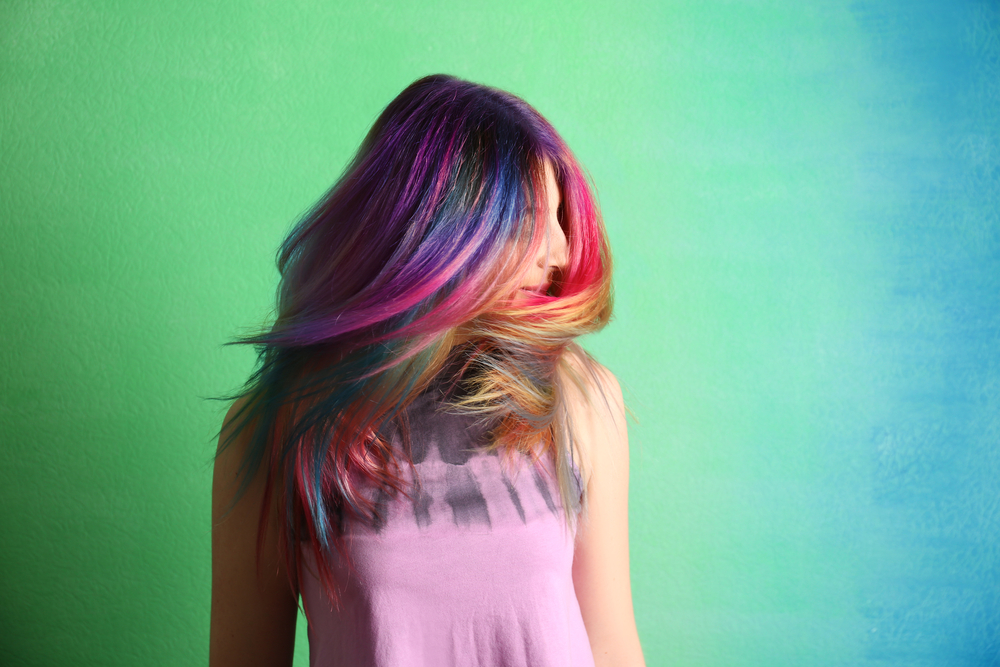 Prismatic Oil Slick Hair on a woman in a green and blue room