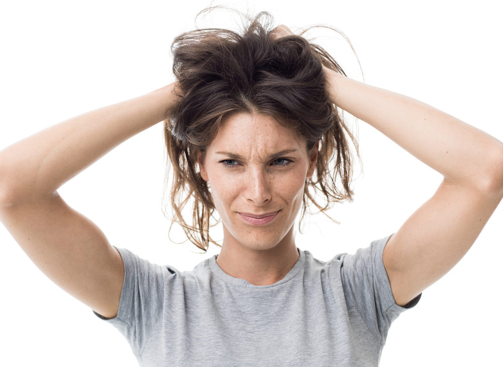 Woman holding her hair wondering why her hair is poofy