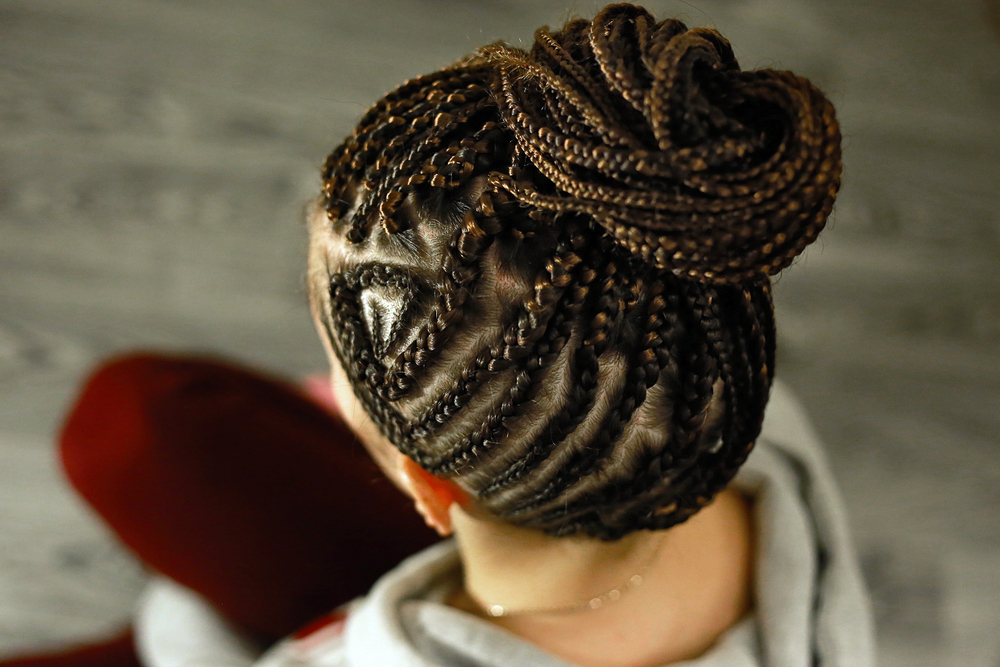 How to clean a scalp with braids without washing featuring a woman with braids sitting on a chair