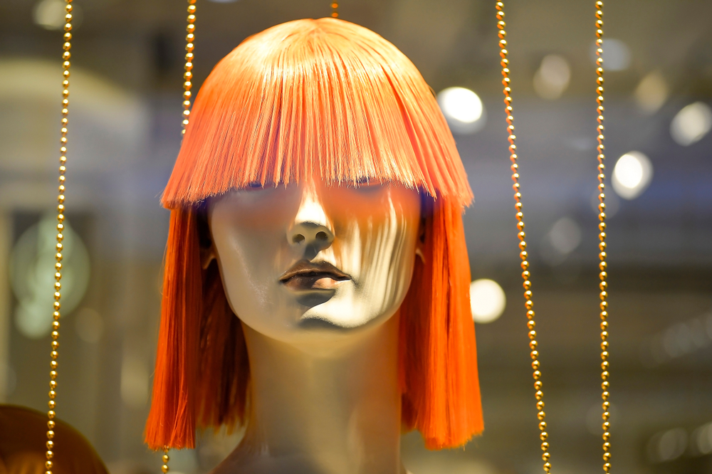 Image of an orange wig on a mannequin for a piece on how to wash a wig with fabric softener