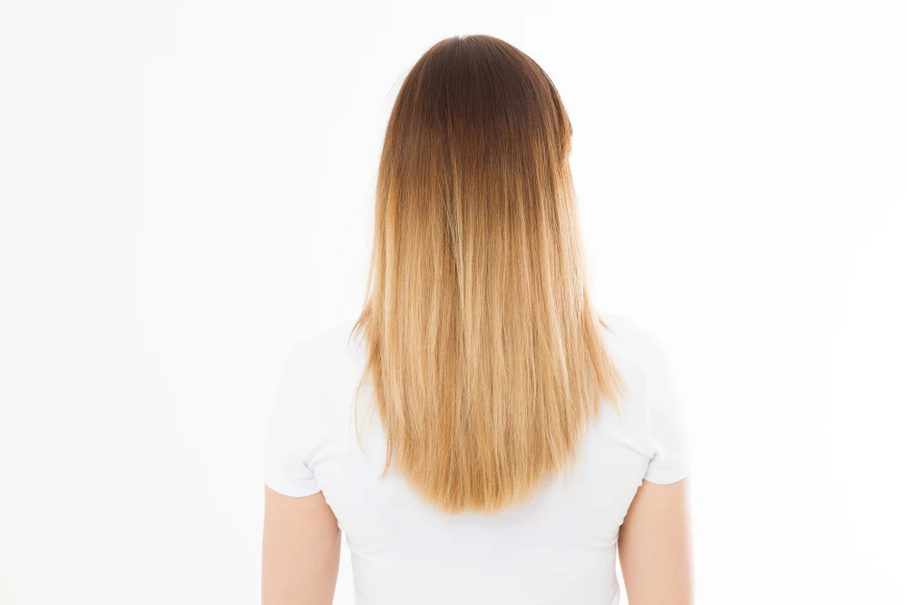 As an idea for brown to blonde ombre hair color style, a woman wears Light Brown, Dark Golden, and Light Golden Blonde Ombre Melt
